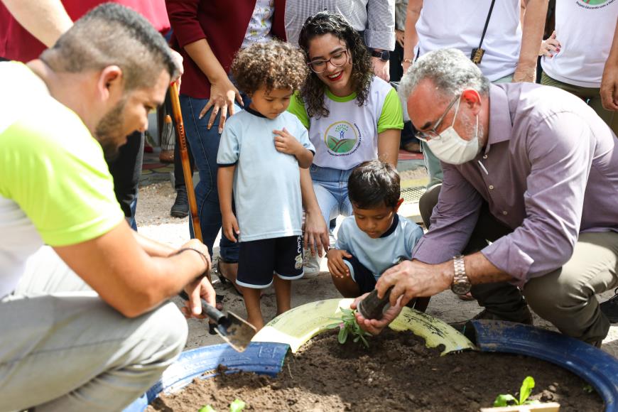 Na inauguração da UEI Rosemary Jorge, o prefeito Edmilson Rodrigues plantou mudinhas de cariru com os alunos.